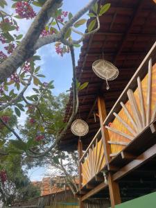 a building with two baskets hanging from a tree at Vila Entreluas in Morro de São Paulo
