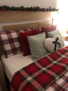 een bed met geruite kussens en een teddybeer bij Alojamiento Fragata Lealtad in Moaña +29 foto's