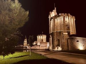 a castle is lit up at night at LoveroomL1TIMISTE TAR in La Rochelle