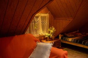 a person sitting on a bed in a room at Wood House w Kotlinie Kłodzkiej in Kłodzko