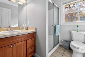 a bathroom with a toilet and a sink and a window at Pet-friendly Grass Lake Hideaway in Grass Lake