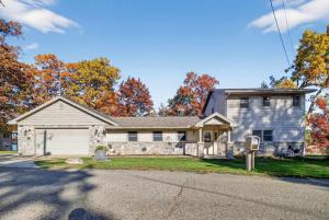 a gray house with a white garage at Pet-friendly Grass Lake Hideaway in Grass Lake