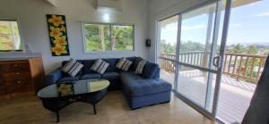 a living room with a blue couch and a balcony at Ocean Beach Town View - Infinity Pool in Avarua