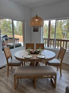 ein Esszimmer mit Tisch und Stühlen und Fenstern in der Unterkunft Brand New Cabin with Fire Pit & Outdoor Projector in Duck Creek Village