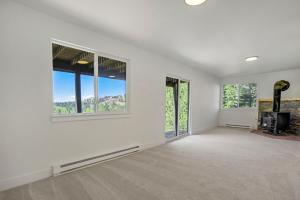 an empty living room with white walls and windows at The Enchanted Summit in Cripple Creek