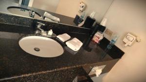 a bathroom counter with a sink and a mirror at Barrokas Inn in Piedras Negras