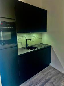 a kitchen with dark blue cabinets and a sink at Good Vibes Luxury Homes in Kaiserslautern