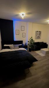 a bedroom with a black bed and a blue light at Good Vibes Luxury Homes in Kaiserslautern