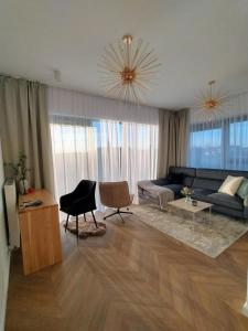 ein Wohnzimmer mit Sofa und Tisch in der Unterkunft Olszynki Park City View in Rzeszów + 26 Fotos