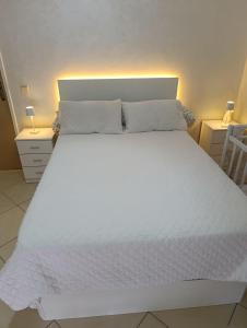 a large white bed in a room with two night stands at El rincón tranquilo in Tetouan