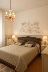 a bedroom with a large bed and a chandelier at DesireeHoliday in Le Grazie