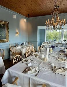 a dining room with white tables and chairs and a chandelier at Rent your own Boutiqe hotel in Skammestein