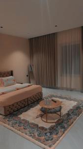 a bedroom with a bed and a coffee table at شقة مفروشة in Jazan