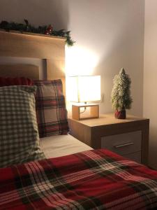 een slaapkamer met een bed en een lamp op een tafel bij Alojamiento Fragata Lealtad in Moaña