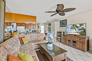 a living room with a couch and a tv at Mahina Surf 117 in Honokowai