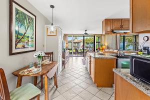a kitchen with a table and a dining room at Mahina Surf 117 in Kapalua