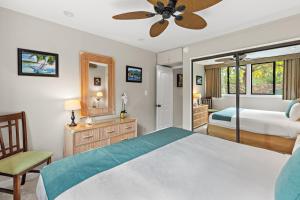a bedroom with a bed and a ceiling fan at Mahina Surf 117 in Kapalua +31 photos