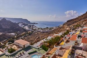 a view of a town on a hill with the ocean at CASA TONINO in Mogán