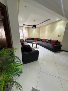 una amplia sala de estar con sofás y una mesa en Beachfront bliss, en Tánger