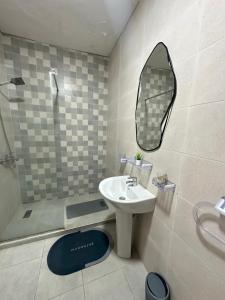 Un baño con lavabo y ducha con espejo. en Beachfront bliss, en Tánger