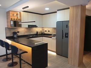 a kitchen with a black counter and a refrigerator at Casa Larrea in Cuenca +6 photos