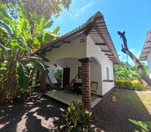 a small white house with a porch at Rancho de Pedro in El Viejo