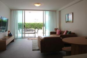 a living room with a couch and a table at Kirra Surf Apartments in Gold Coast +182 photos