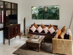 Una sala de estar con un sofá y una mesa de café. en Villa MONTI - LEGIAN - SEMINYAK - Lovely 2 Bedroom Villa - Great Location !, en Seminyak