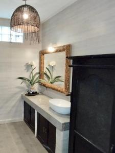 un baño con lavabo y espejo en Villa MONTI - LEGIAN - SEMINYAK - Lovely 2 Bedroom Villa - Great Location !, en Seminyak