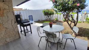 a patio with a table and chairs and a piano at Tongoy Bauhaus - Alojamiento hasta 12 personas in Tongoy
