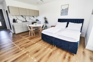 KomendaBlue Alpine Nest的一间带床、桌子的卧室和一间厨房 更多9张照片