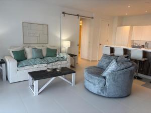 a living room with a couch and two chairs and a table at Indigo Escape in Koolbaai