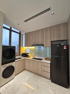a kitchen with a black refrigerator and a sink at Panorama luxury Suites At TM Persiaran Stonor KLCC in Kuala Lumpur