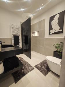 ein Badezimmer mit einer weißen Toilette und einem Waschbecken in der Unterkunft Good Vibes Luxury Homes in Kaiserslautern