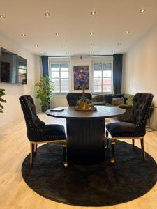 ein Wohnzimmer mit Tisch und Stühlen in der Unterkunft Good Vibes Luxury Homes in Kaiserslautern