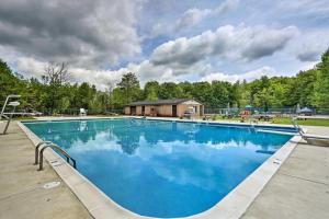 a large blue swimming pool with a building in the background at Home in Arrowhead Lake Pocono PA - Lake Access, Hot Tub, Fire Pit, and Amenities Included in Arrowhead Lake