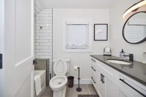 a white bathroom with a toilet and a sink at 3 Bedroom -walk To The Falls in Niagara Falls