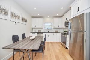 a kitchen with a wooden table and a refrigerator at 3 Bedroom -walk To The Falls in Niagara Falls