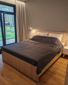 a large bed in a bedroom with a large window at Baltic Jet Silver Sea in Ustronie Morskie +31 photos