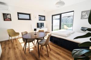 a bedroom with a bed and a table and chairs at Green Alpine Nest in Komenda