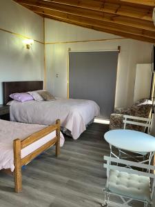 une chambre avec deux lits et une table dans l'établissement Hostal patronal bypass el rosal k485, à Salto del Laja