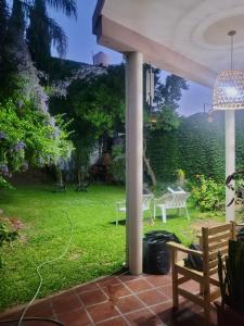 een terras met uitzicht op een tuin met banken bij Residencia La Serena in Bernal