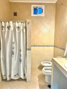 a bathroom with a shower curtain and a toilet at Residencia La Serena in Bernal +25 photos