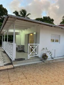 a white house with a white porch and a porch at Logement à trois rivières à 5min de l embarcadère in Trois-Rivières