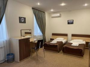 een hotelkamer met twee bedden en een bureau bij Нивки плаза апартаменти in Kiev