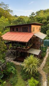 una pequeña casa con techo naranja y porche en Utopia Bluff Beach Off Grid Jungle Retreat By The Sea, en Bocas Town
