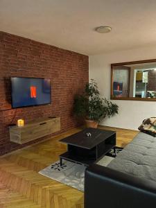 a living room with a tv on a brick wall at TRUTH Apartment Veles in Veles