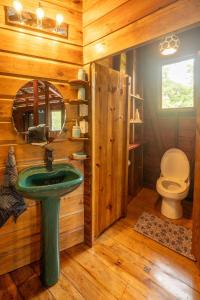 Un baño con un lavabo verde y un inodoro. en Utopia Bluff Beach Off Grid Jungle Retreat By The Sea, en Bocas Town 20 fotos más