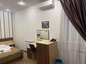 een kamer met een bureau met een spiegel en een bed bij Нивки плаза апартаменти in Kiev