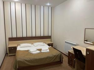 een slaapkamer met een bed, een bureau en een spiegel bij Нивки плаза апартаменти in Kiev